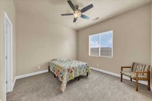 Carpeted bedroom featuring baseboards and ceiling fan