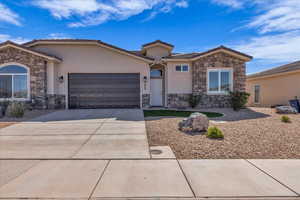 Ranch-style home featuring stone siding, stucco siding, a garage, and a tiled roof