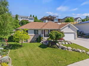 Single story home featuring concrete driveway, an attached garage, and covered porch