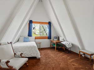 Bedroom with vaulted ceiling and carpet