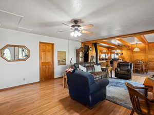 Living room featuring wood walls, light wood-style flooring, baseboards, and plenty of natural light