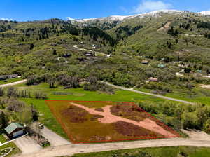 Aerial view of property's location with a mountain backdrop and property parcel outlined