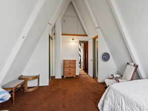 Bedroom with carpet floors and vaulted ceiling