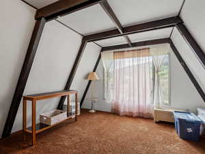 Bonus room with carpet flooring and beamed ceiling