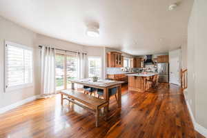 Dining room featuring dark wood-style flooring and baseboards