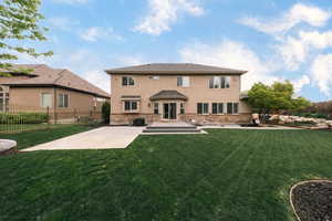 Rear view of house with a patio, stucco siding, stone siding, and central AC unit