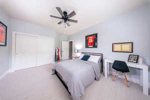 Bedroom featuring a closet, carpet flooring, baseboards, a ceiling fan, and vaulted ceiling