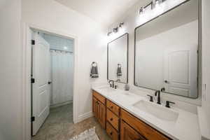 Bathroom featuring double vanity and baseboards