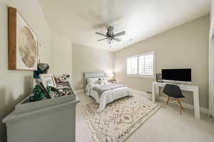 Bedroom featuring carpet, an office area, ceiling fan, baseboards, and vaulted ceiling