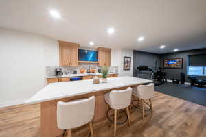 Kitchen with a sink, tasteful backsplash, a breakfast bar area, a center island, and light countertops