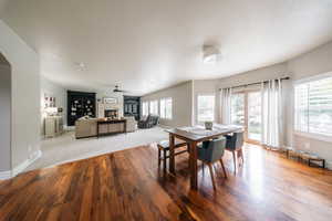 Dining area featuring healthy amount of natural light, wood finished floors, a fireplace, and baseboards