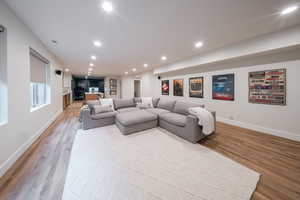 Living area with wood finished floors, baseboards, and recessed lighting