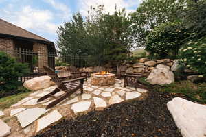 View of patio featuring a fire pit and fence