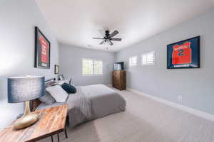 Carpeted bedroom with baseboards and a ceiling fan