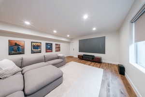 Living room with wood finished floors, baseboards, and recessed lighting