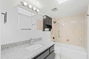 Full bathroom with toilet,  shower combination, and vanity