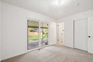 Unfurnished bedroom featuring access to outside, carpet floors, and baseboards