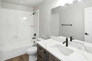 Full bathroom featuring vanity, wood finished floors, and shower / tub combination