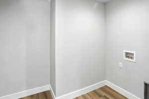 Laundry room with hookup for a washing machine and wood finished floors