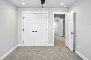 Unfurnished bedroom featuring carpet floors, recessed lighting, and a closet