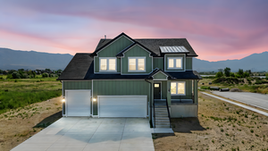 View of front facade with a mountain view, concrete driveway, a garage, and board and batten siding
