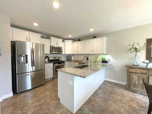 Kitchen with appliances with stainless steel finishes, a Farmhouse sink, Granite Counters