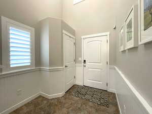 Entrance foyer with a high ceiling and a wainscoted wall