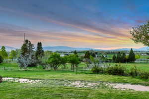 Yard at dusk featuring a view of rural / pastoral area and a mountain view