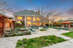 Back of property with a gazebo, brick siding, a tiled roof, and a patio