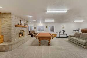 Game room featuring billiards, carpet flooring, a fireplace, and ornamental molding