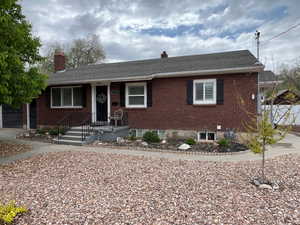 Single story home featuring brick siding, a chimney, and a shingled roof