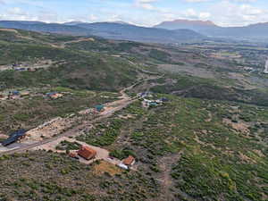 Aerial view of property and surrounding area featuring a mountain backdrop