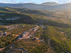 Aerial view of property and surrounding area featuring a mountainous background