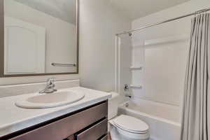 Full bath with vanity, toilet, and shower / tub combo