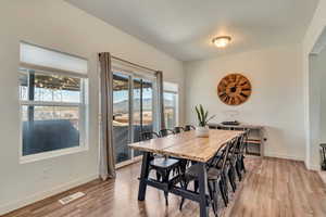 Dining room featuring light wood-style flooring, baseboards, and a textured ceiling