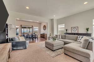 Carpeted living area featuring recessed lighting and a textured ceiling