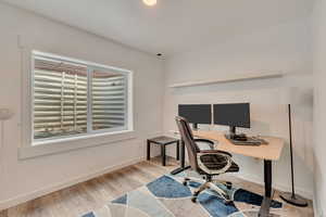 Office with wood finished floors and baseboards