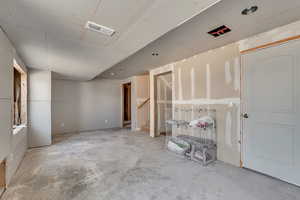 Unfurnished living room with unfinished concrete flooring and stairs