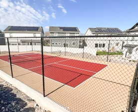 View of basketball court with a tennis court and fence