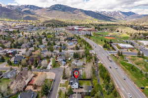 Aerial view of property's location with a mountainous background, a main thoroughfare, and nearby suburban area