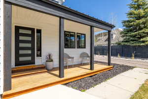 Doorway to property with fence and covered porch