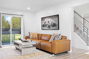 Living area featuring stairs, wood finished floors, recessed lighting, and baseboards