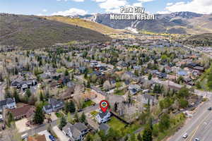 Aerial view of property and surrounding area with mountains and nearby suburban area