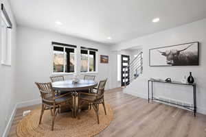 Dining area with stairs, light wood-type flooring, recessed lighting, and baseboards