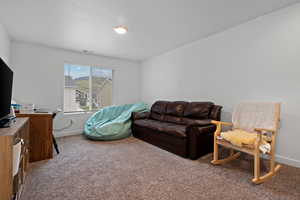 Living room featuring carpet floors, baseboards, and an office area