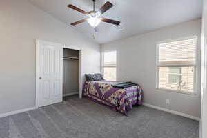 Bedroom with a closet, visible vents, carpet, baseboards, and lofted ceiling