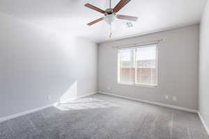 Spare room featuring visible vents, light carpet, and baseboards