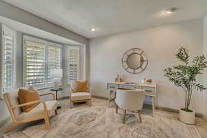Home office featuring a textured ceiling and baseboards