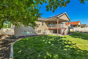 Rear view of house featuring stairs, a patio area, a wooden deck, solar panels, and central AC