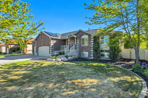 Ranch-style home with brick siding, roof mounted solar panels, concrete driveway, a garage, and roof with shingles